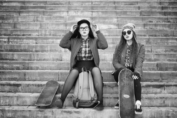 A young hipster girl is riding a skateboard. Girls girlfriends f — Stock Photo, Image