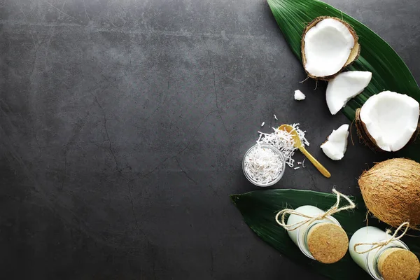Kokos na ciemnym kamiennym stole. Olej kokosowy. — Zdjęcie stockowe