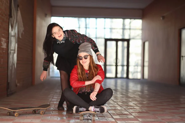 Una giovane hipster sta cavalcando uno skateboard. Ragazze amiche f — Foto Stock