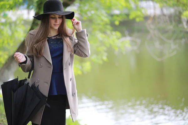 Jeune fille dans un manteau dans un parc de printemps — Photo