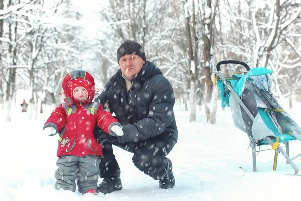 Father with daughter in the park in winter snow blizzard