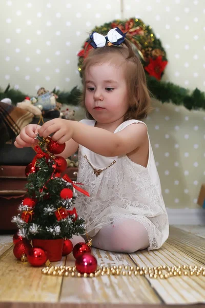 크리스마스 트리 앞에 앉아 어린 소녀 — 스톡 사진