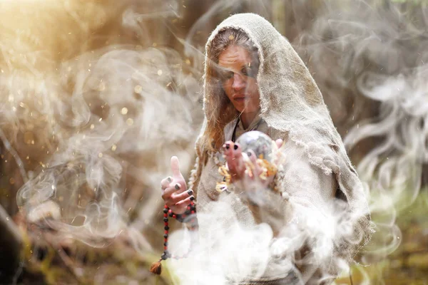 A man in a cassock spends a ritual in a dark forest — Stock Photo, Image