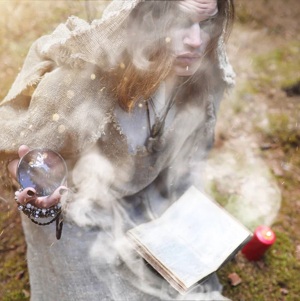 Un homme en soutane passe un rituel dans une forêt sombre — Photo