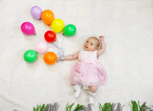 Niña sosteniendo un montón de globos y espectáculos de vuelo — Foto de Stock