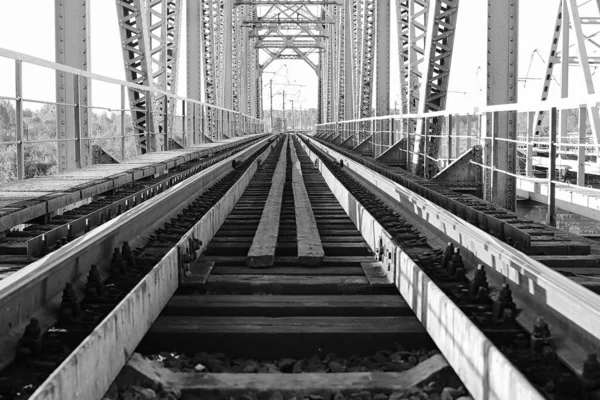 Foto monocromática del puente en las vías del ferrocarril e indust — Foto de Stock