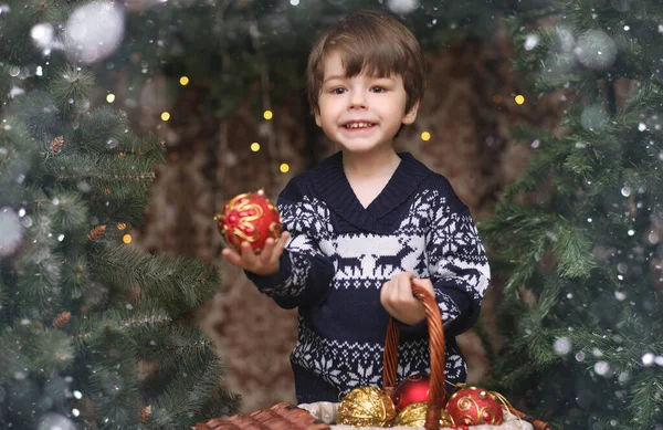 A little child by the New Year tree. Children decorate the Chris — Stock Photo, Image