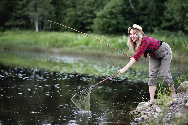 Ragazza vicino al fiume con una canna da pesca — Foto Stock
