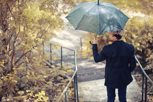 Autumn rainy weather and a young man with an umbrella Stock Photo