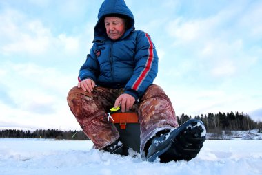 Göl kenarında balıkçı kış