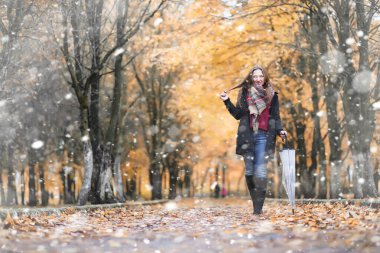 Parkta ilk kar yağışında bir kız