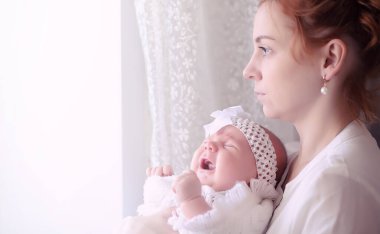 Anne kucağında yeni doğmuş bir bebekle. Kızın kucağında bir bebek var. 