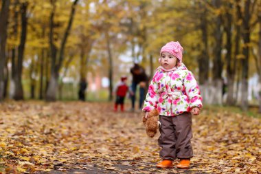 Sonbahar parkında yürüyüş yapan bir çocuk.