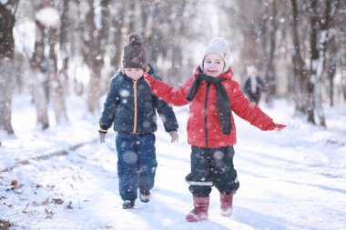 Çocuklar parkta ilk kar yürümek