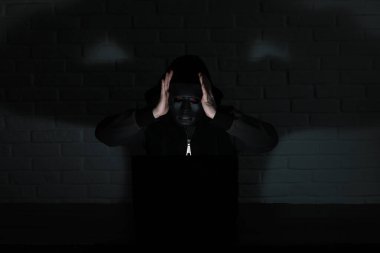 Siyah maske ve hood masada hacker