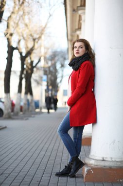 Şehirde kırmızı paltolu bir yolda güzel kız