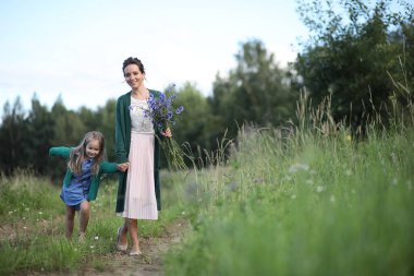 Anne ve kızı yolda yürüyor.