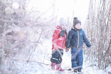 Çocuklar parkta ilk kar yürümek