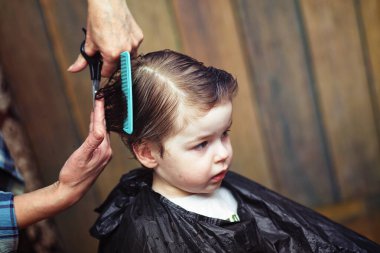 Küçük bir çocuk kuaförde kesilmiş. 