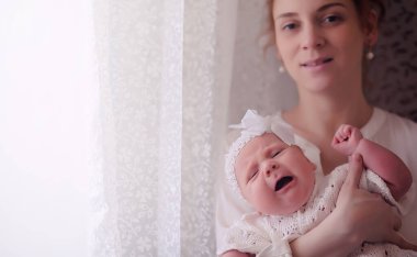 Anne kucağında yeni doğmuş bir bebekle. Kızın kucağında bir bebek var. 