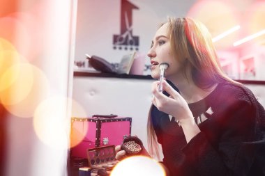 Genç bir kız bir güzellik salonu makyaj yapar. Kız açık o