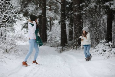 Genç bir aile yürüyüşe çıktı. Anne ve kızı şarapla yürüyorlar.