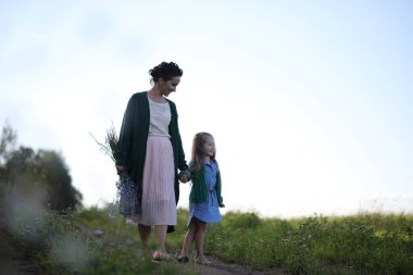 Anne ve kızı yolda yürüyor.