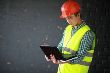 Kask ve inşaat koruyucu yelek Asyalı adam