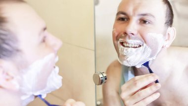 Bir adam sabahları banyoda tıraş oluyor.