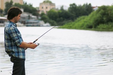 Bir sakallı bir adam nehirde balık tutma