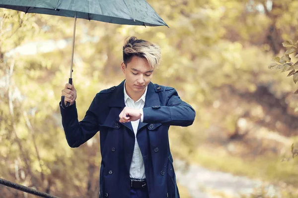 Automne temps pluvieux et un jeune homme avec un parapluie — Photo