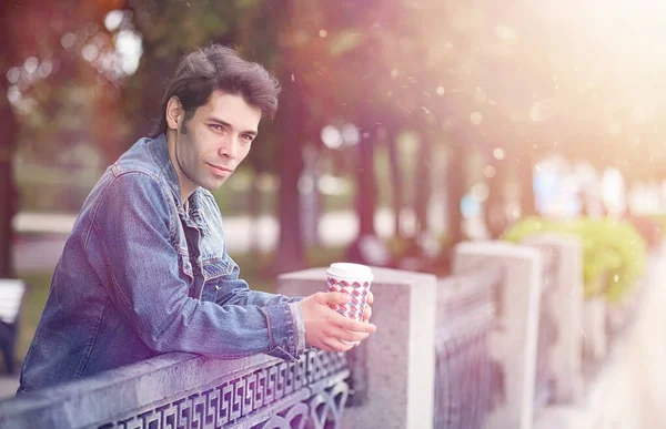 A young man walks in the park at lunch time. A man is on a walk