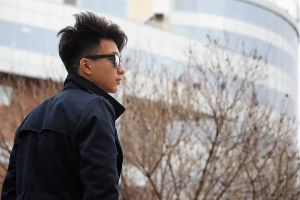 Asiatique jeune homme dans un manteau sur la rue — Photo