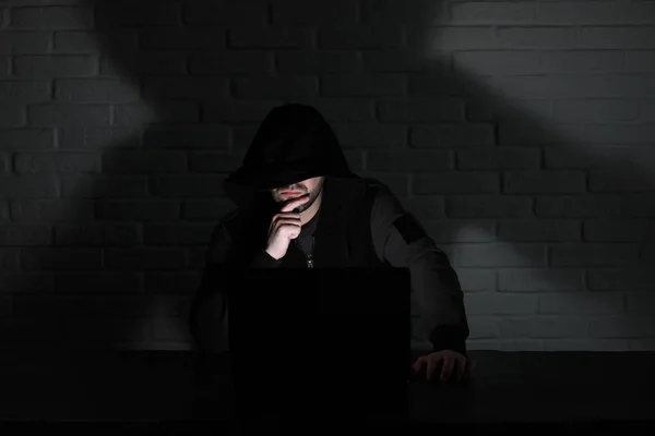 Hacker con máscara negra y capucha en la mesa — Foto de Stock