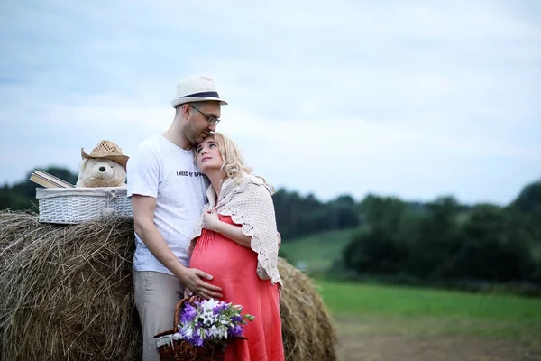 Fille enceinte avec gros ventre et jeune homme en plein air — Photo