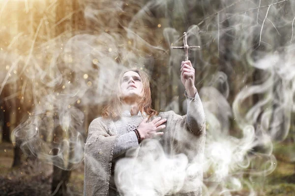 Un homme en soutane passe un rituel dans une forêt sombre — Photo