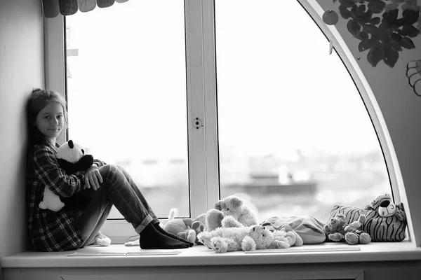 Child in the children's room. The kid is sitting on the windowsi — Stock Photo, Image