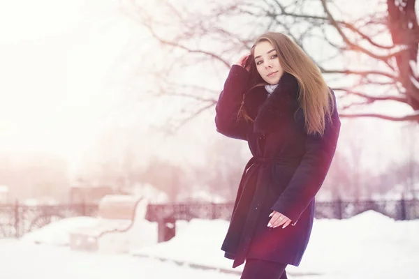 Uma menina em um parque de inverno em uma caminhada. Festas de Natal em t — Fotografia de Stock