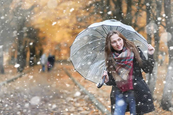 Egy lány a parkban az első hóesésben. — Stock Fotó