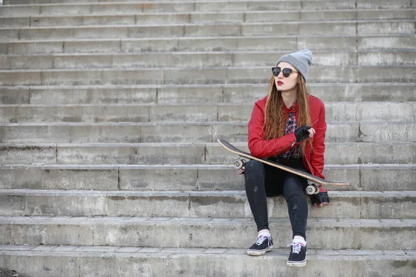 Una giovane hipster sta cavalcando uno skateboard. Ragazze amiche f — Foto Stock