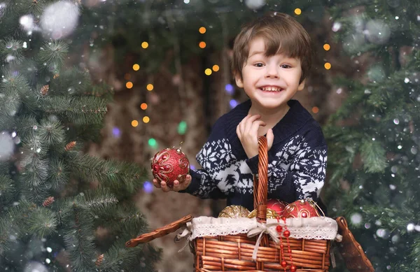 A little child by the New Year tree. Children decorate the Chris — Stock Photo, Image