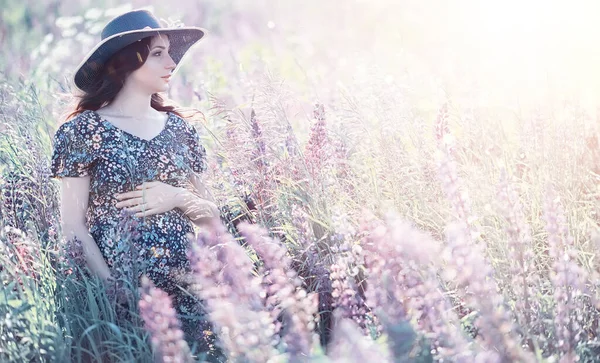 Вагітна дівчина в полі з квітами — стокове фото