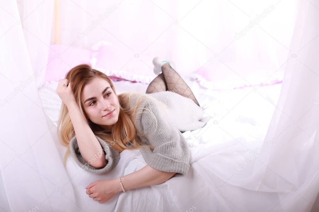 Girl with blond hair and gray sweater