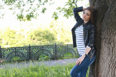 Genç kız bir yürüyüş. Kız sokakta bir deri ceketli. Olmak