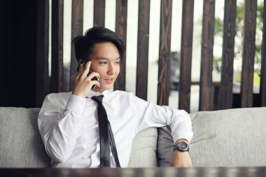 Genç Asyalı işadamı bir kafede bir ortak için bekliyor. Bu