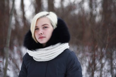 Genç ve güzel bir kız kış parkında yürüyüşe çıkmış.