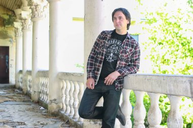 Adam terk edilmiş merdivenlerde oturuyor.