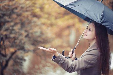 Sonbahar yağmurlu hava ve bir şemsiye ile genç bir adam