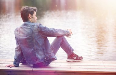 Genç bir adam öğle yemeği zamanında parkta yürür. Bir adam yürüyüşe çıktı. 