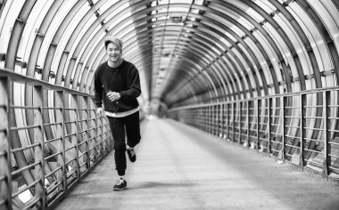 Spor giyimli bir adam açık havada tek renkli fotoğraf çalıştırın